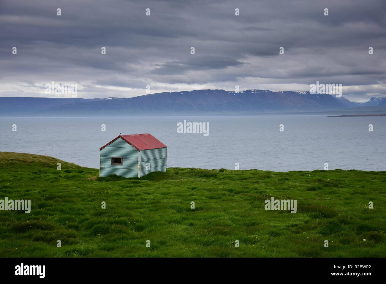 Icelandic landscape. A tin shack at the ocean with a red roof. Peninsula Skagi, Skagafjördur. Stock Photo