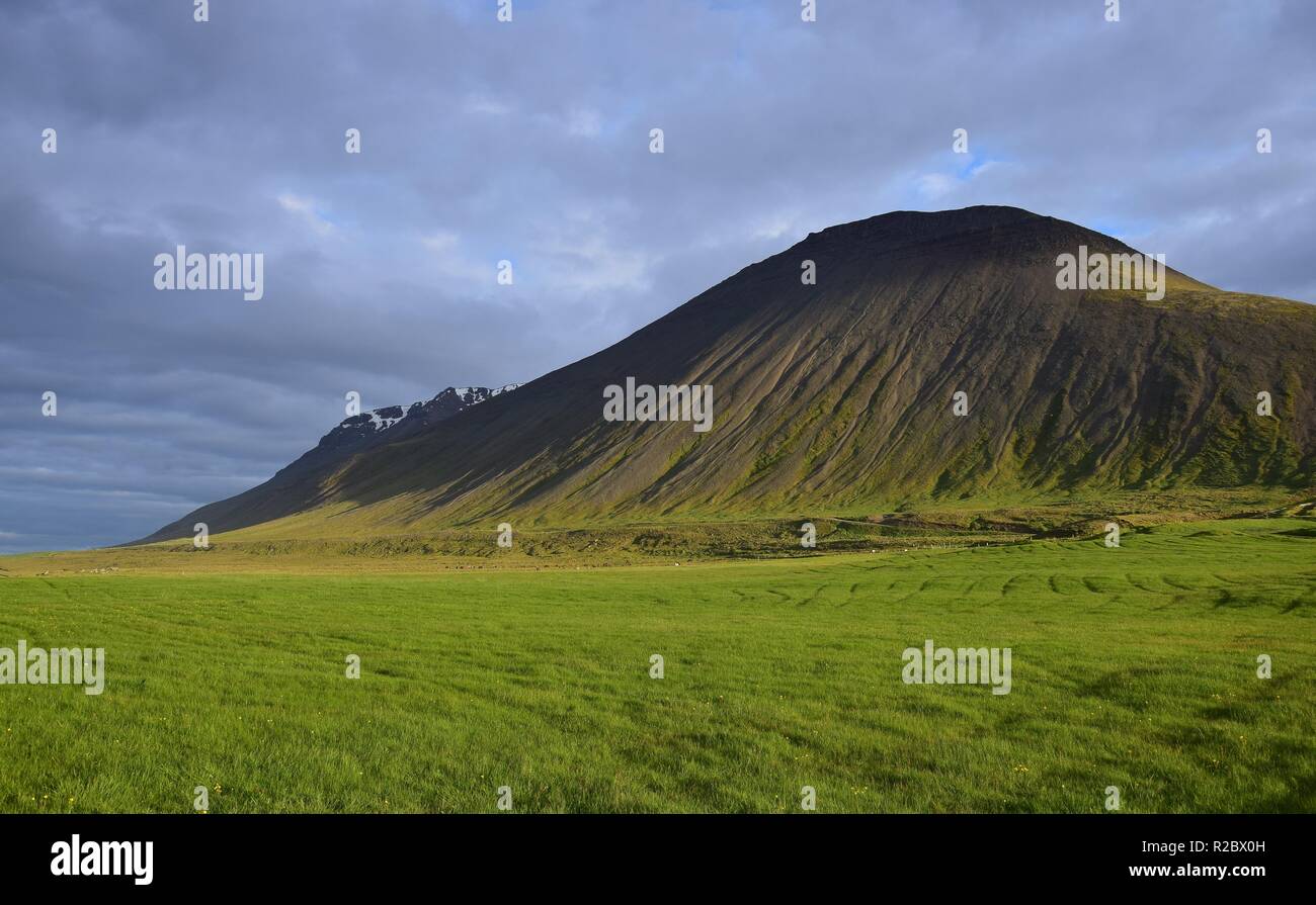 Icelandic landscape near the hot pot Grettislaug on peninsula Skagi. A mountain named Sandfell in the evening sun. Stock Photo