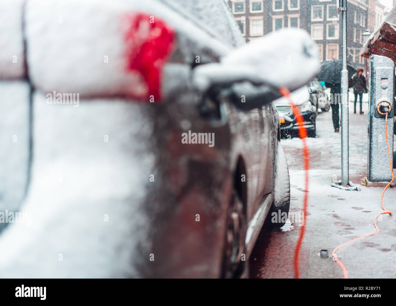 Electric car plug charging in the winter Stock Photo Alamy
