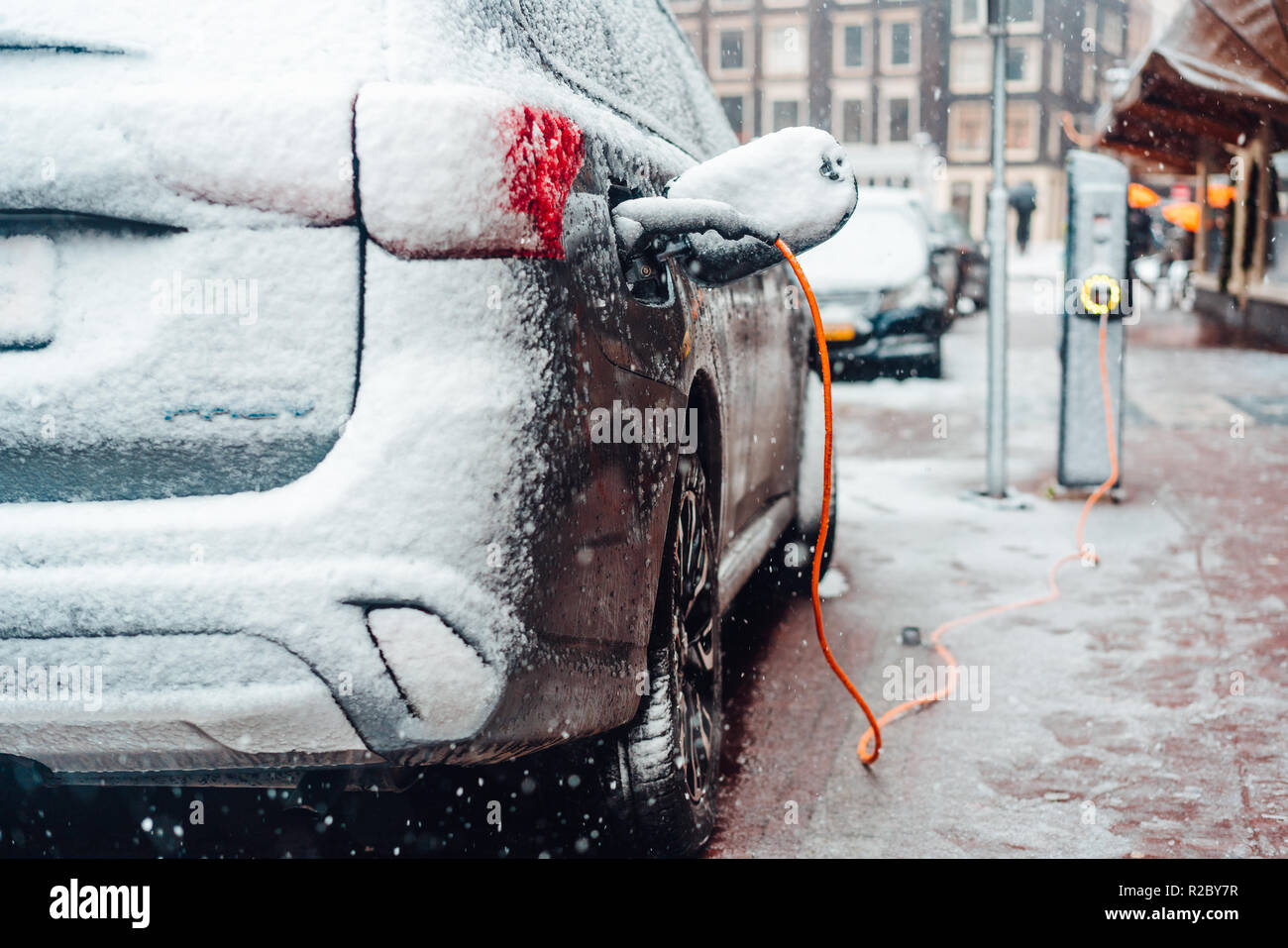 Electric car plug charging in the winter Stock Photo Alamy