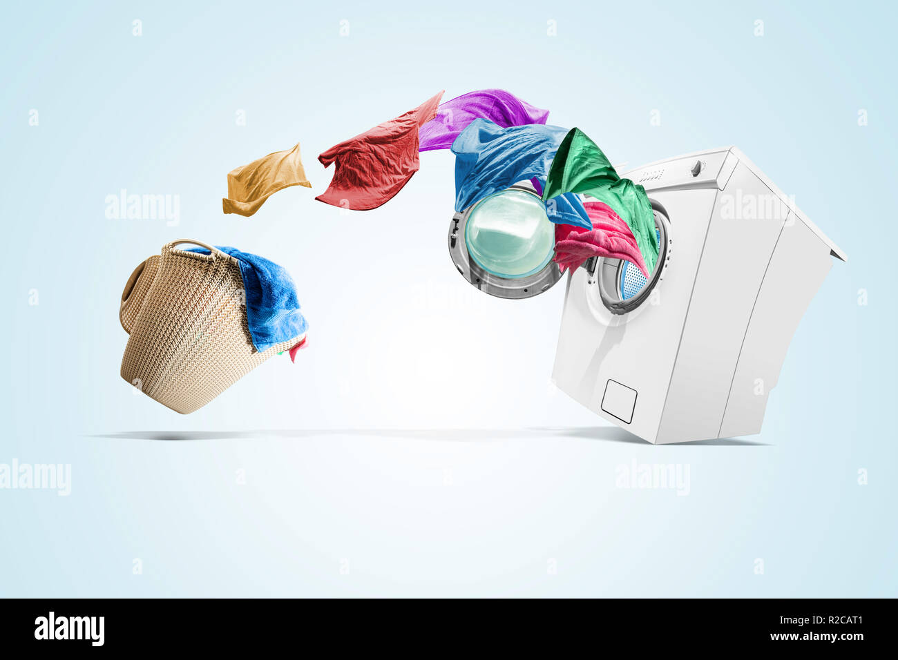 Clothing from laundry basket go into the washing machine over white