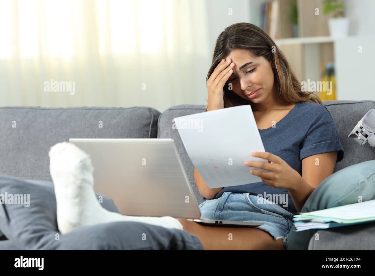 Worried disabled self employed complaining reading dad report while is working at home Stock Photo