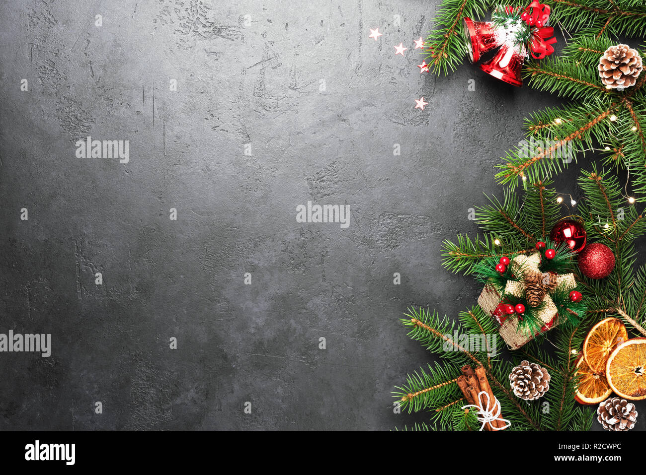 Christmas Background. Fir Tree Decorations Gift Box On Black Concrete With Copy Space. Christmas or New Year festive card Stock Photo