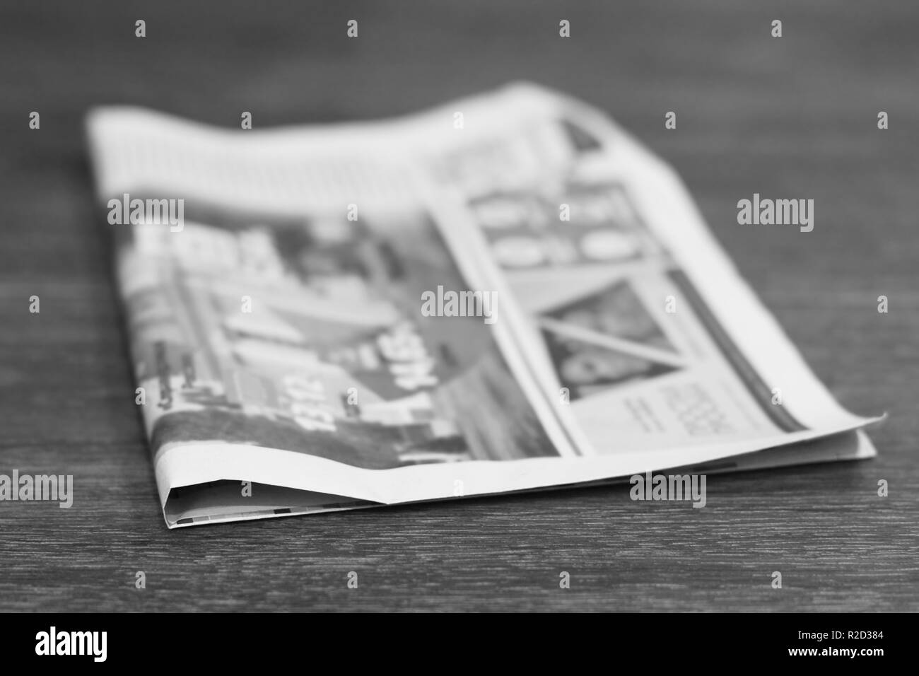 Single newspaper on wooden table, side view Stock Photo