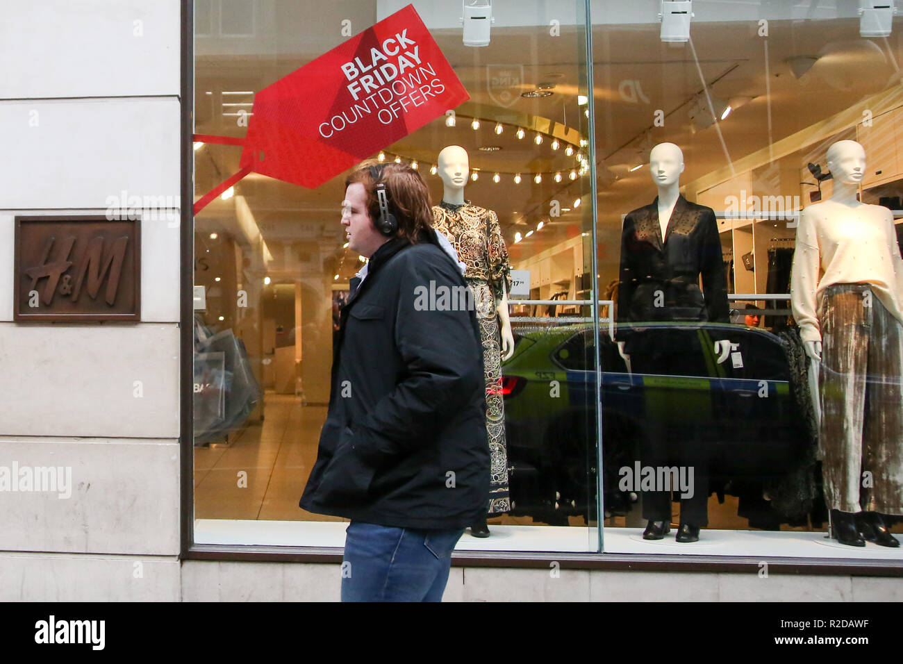 Oxford Street, London, UK 19 Nov 2018 - A shopper walks past H&M store in  Oxford Street. H&M store on LondonÕs Oxford Street gets ready for Black  Friday Event with huge savings.