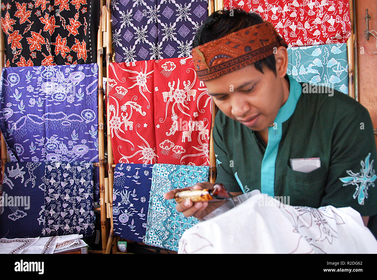 A man is seen painting motifs on a cloth in the traditional way at the Bogor batik gallery. Bogor batik cloth is a unique cleaver motif and drizzle, they are applied in batik strokes that are part of the symbol of the City of Bogor and the deer head motif which is a symbol of the Bogor Palace while the lotus motif is a symbol of the Bogor Botanical Garden, the kujang knife as the symbol of the city of Bogor and the rain motif as the term Bogor city. UNESCO awarded Indonesia batik as a Humanitarian Heritage for Oral and Non-Cultural Heritage (Masterpieces of the Oral and the Intangible Heritage Stock Photo