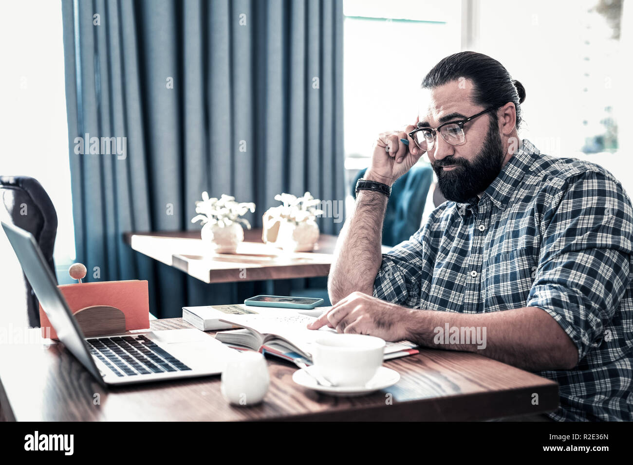 Bearded freelancer feeling overloaded having too many tasks Stock Photo