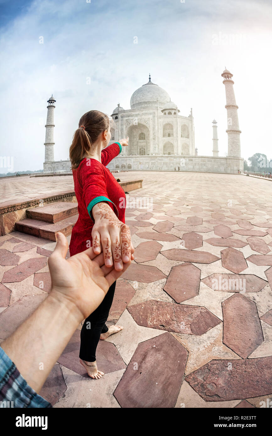 Woman in red Indian costume holding man by hand and pointing to Taj Mahal  in Agra, Uttar Pradesh, India Stock Photo - Alamy