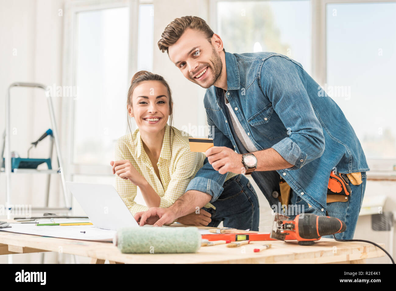 happy young couple with credit card smiling at camera during home improvement Stock Photo