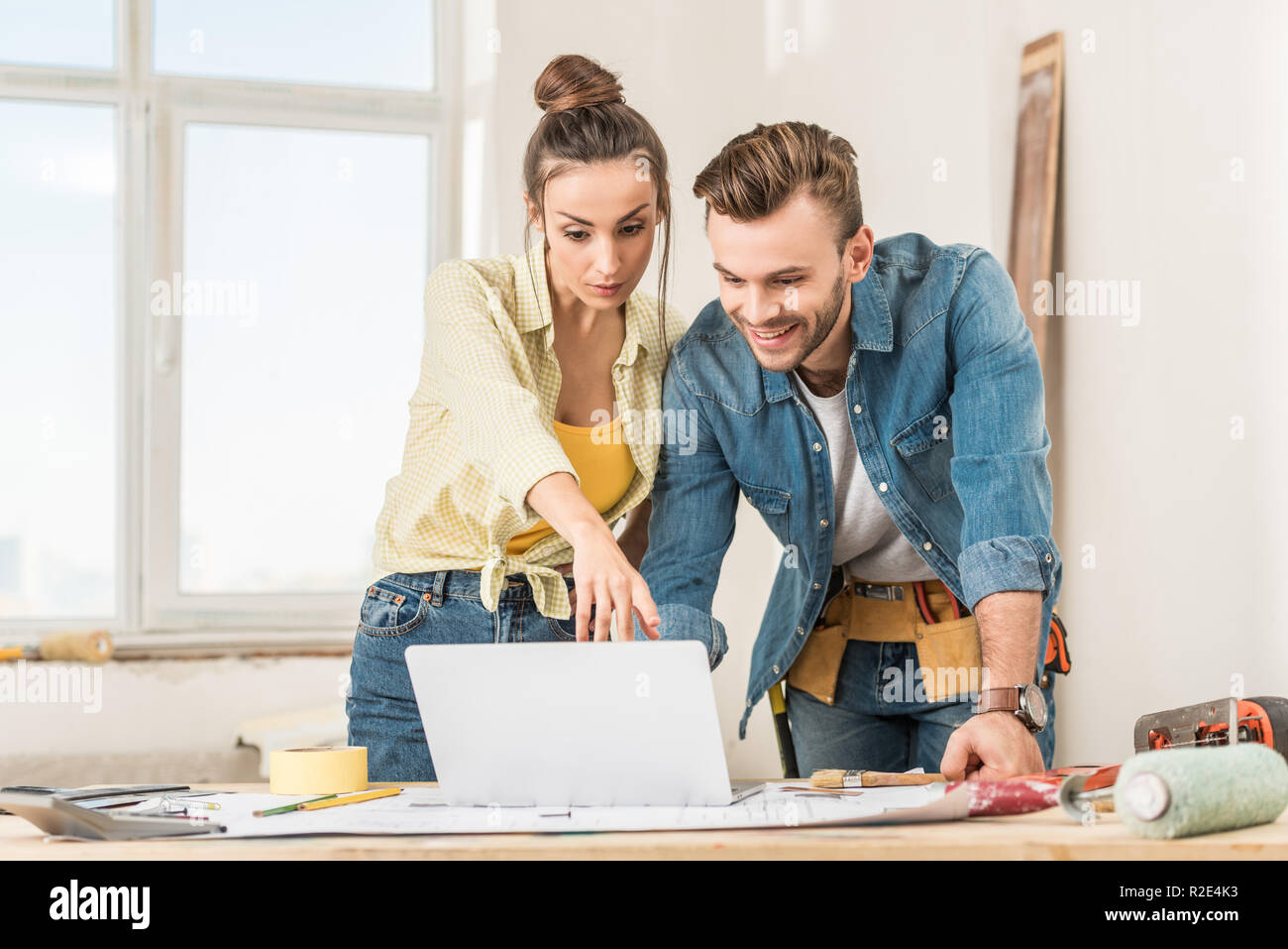 young couple using laptop during home improvement Stock Photo