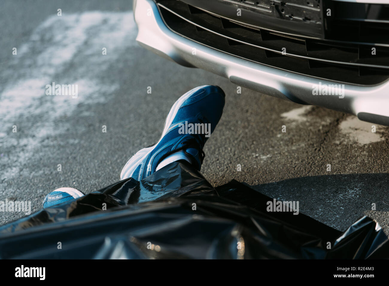 cropped shot of dead man and car on road after motor vehicle collision Stock Photo