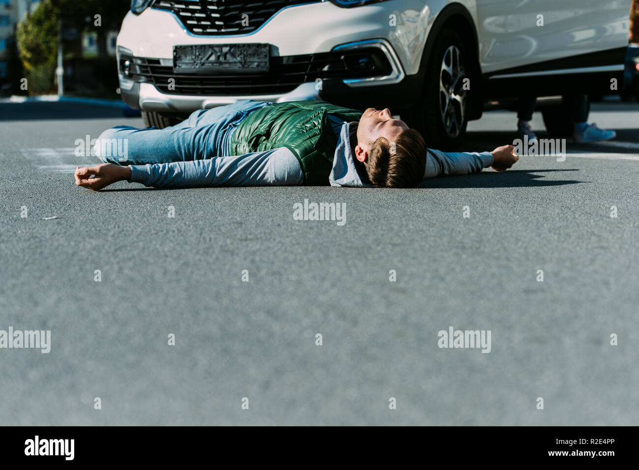 surface level of injured young man lying on road after car accident Stock  Photo - Alamy