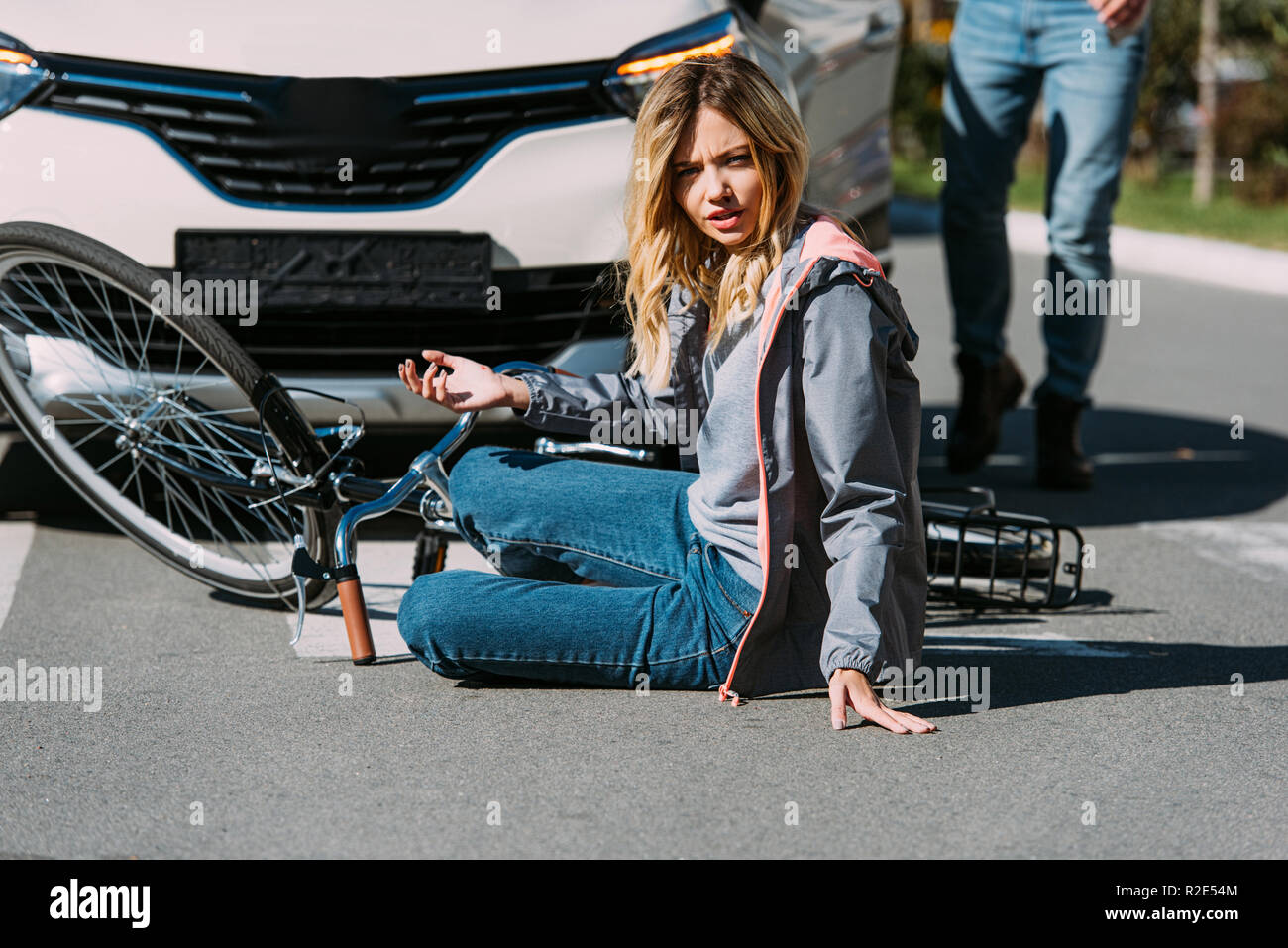 partial view of injured woman on road after car accident with car ...
