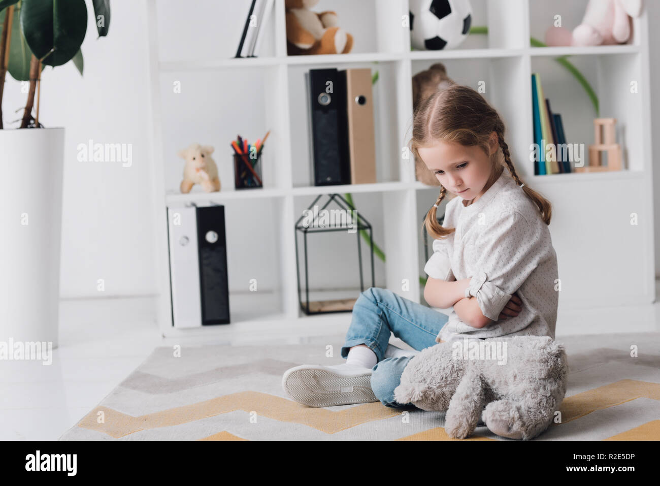 depressed little child sitting on floor with teddy bear Stock Photo - Alamy