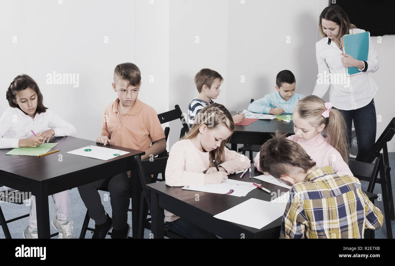 Group of children in elementary age at drawing lesson Stock Photo - Alamy