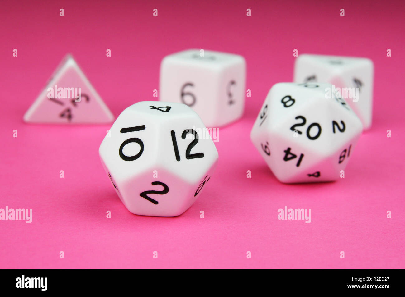 Set of white complete regular platonic solid dice on a pink background Stock Photo