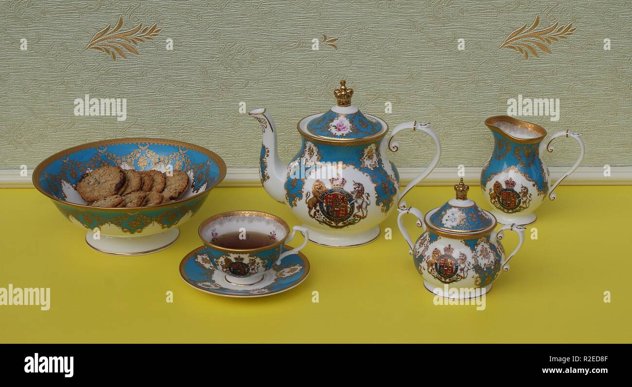 English teacup with saucer, teapot, sugar bowl, cream jug and a cake