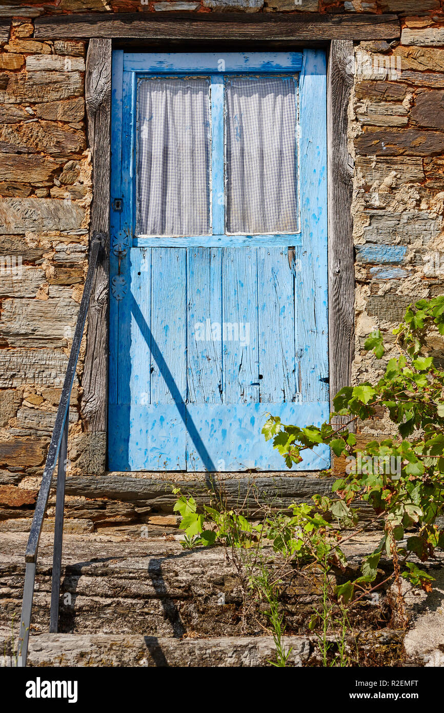 Old rusted blue wooden door and stone house facade. Vertical Stock ...