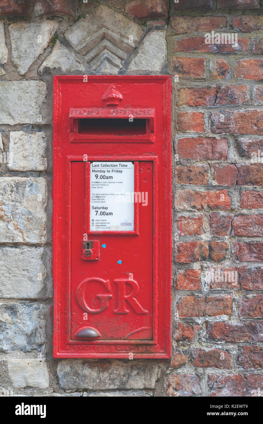 York, UK - April 2018: A red British Wall box set into a wall at York Minster, historic cathedral built in English gothic style in City of York, UK Stock Photo