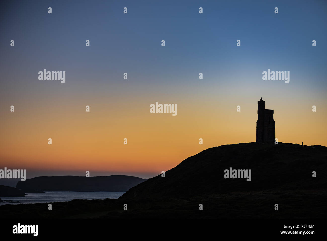 Sunset behind Milner's Tower, Bradda Head, Port Erin, Isle of Man. Calf of Man in background. Stock Photo