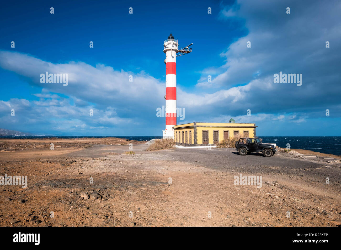 living a dream with a tiny home lighthouse near the coast and the power of the waves. Ocean and sky. Black offroad car parked outside Stock Photo