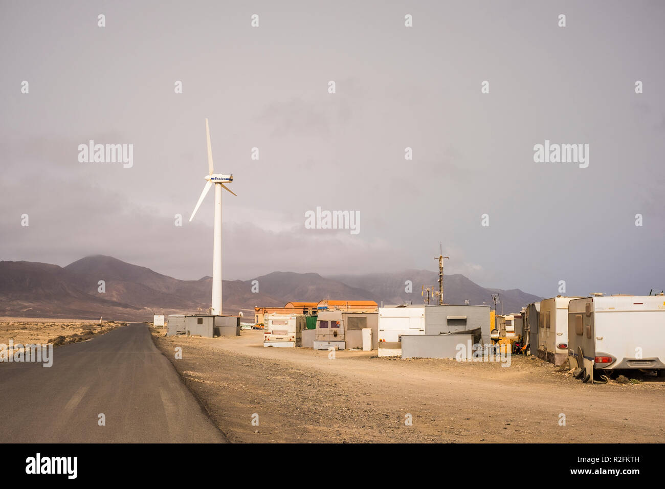independent little town with houses and caravan hippy and out of siciety lifestyle. one road to come and go and one windmil to produce the energy they need to live there or survive. no comfort zone, out of the box life Stock Photo