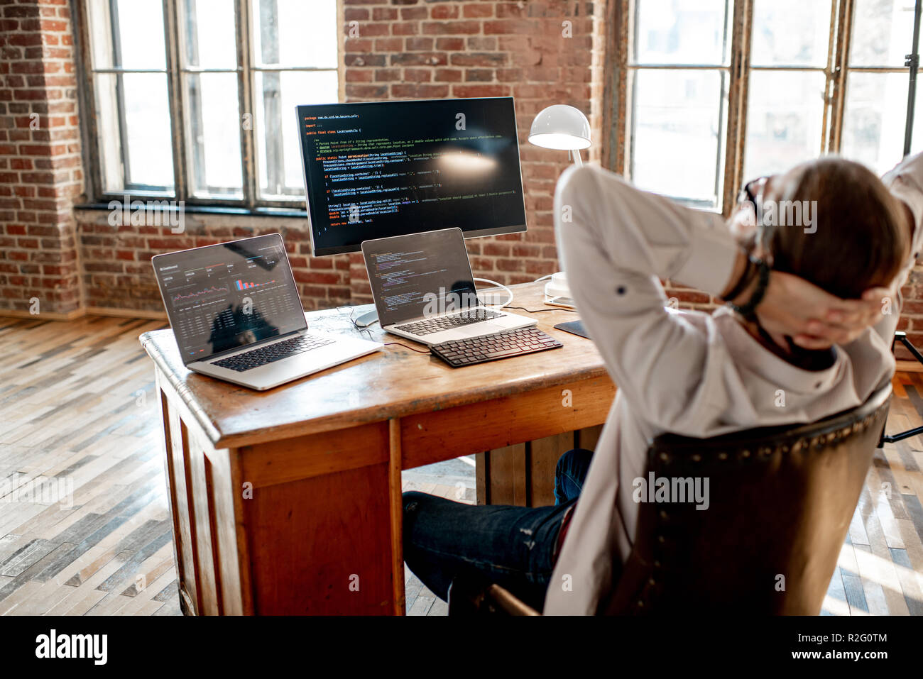 Young male programmer relaxing during the work with program code ...