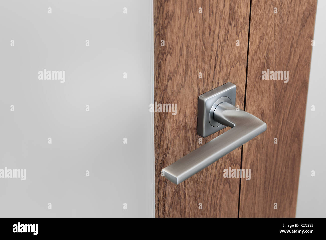Close Up Of Modern Steel Door Handle On Interior Door Dark Oak