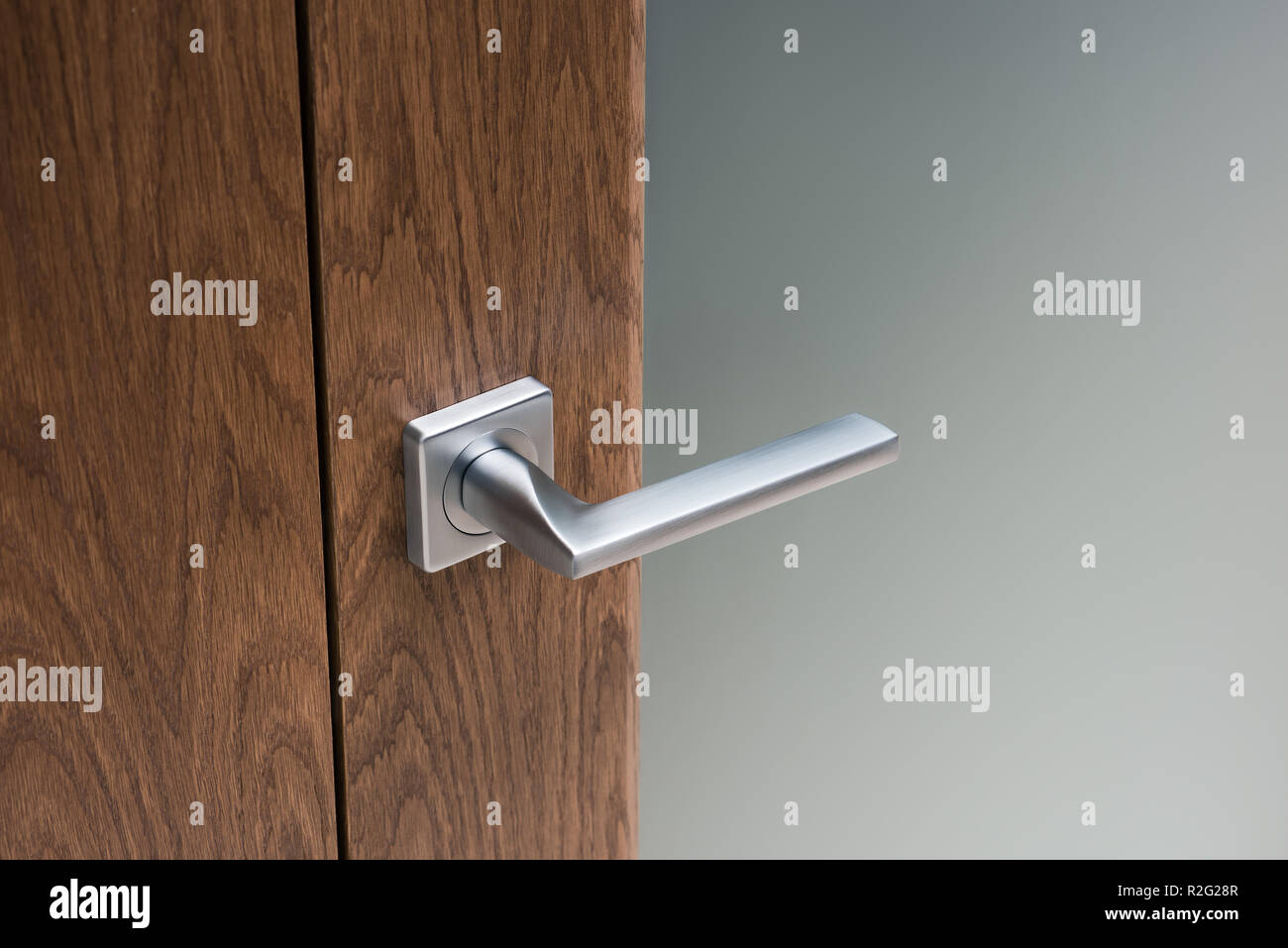 Close Up Of Modern Steel Door Handle On Interior Door Dark Oak