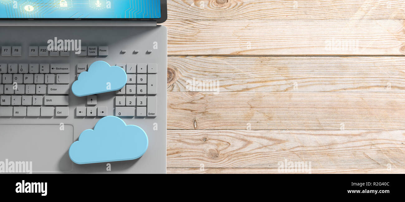 Cloud computing concept, Computer and blue clouds on wooden background ...