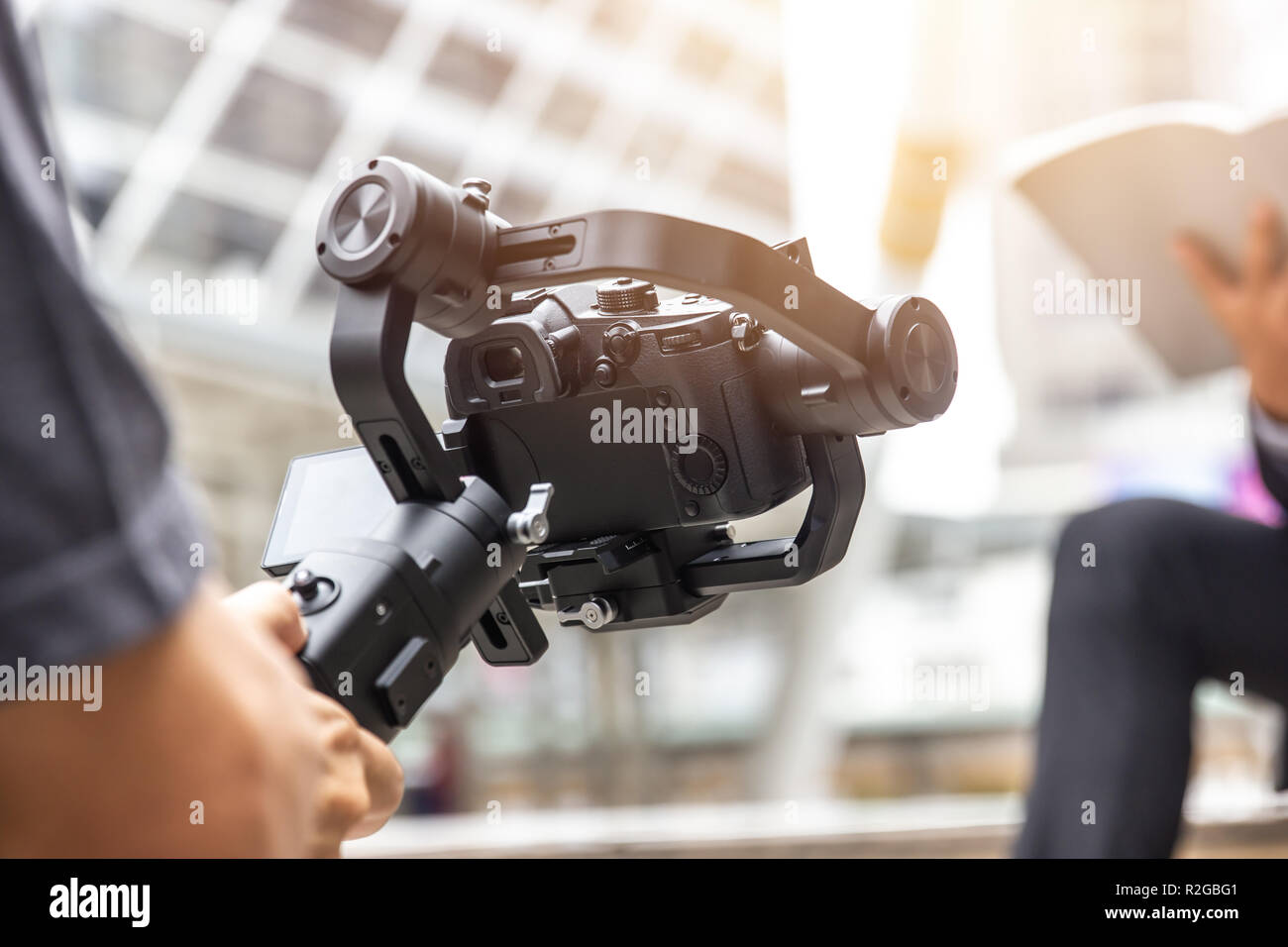 motorized gimbal, videographer using dslr camera anti shake tool  for  stabilizer record video scene. Stock Photo