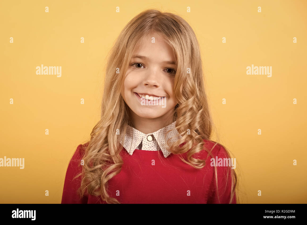 Child With Curly Blond Hair On Orange Background Girl With Smile