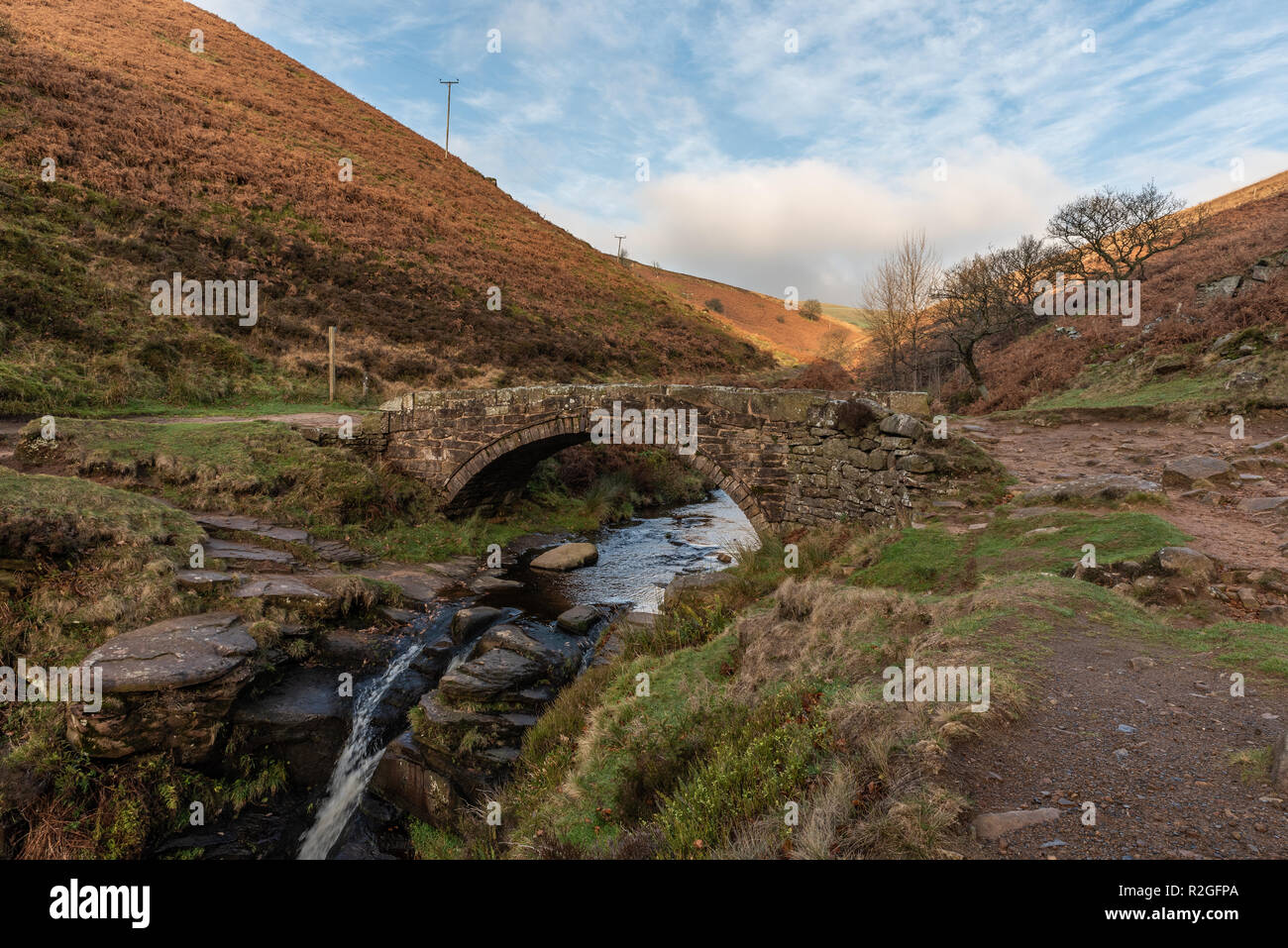 A waterfall and packhorse stone bridge at Three Shires Head in the Peak