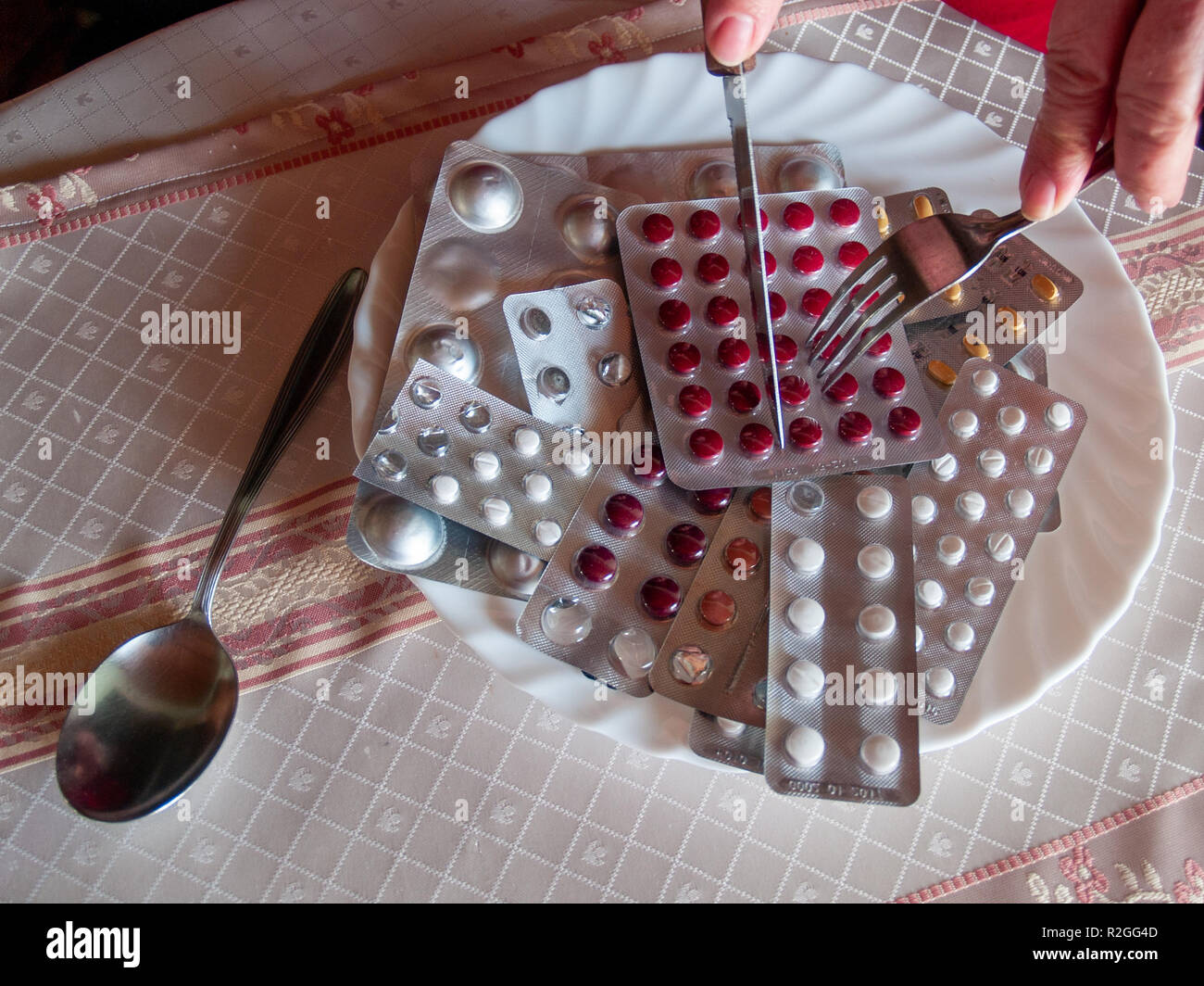Concept of medicine and health care. A person cutting several tablets