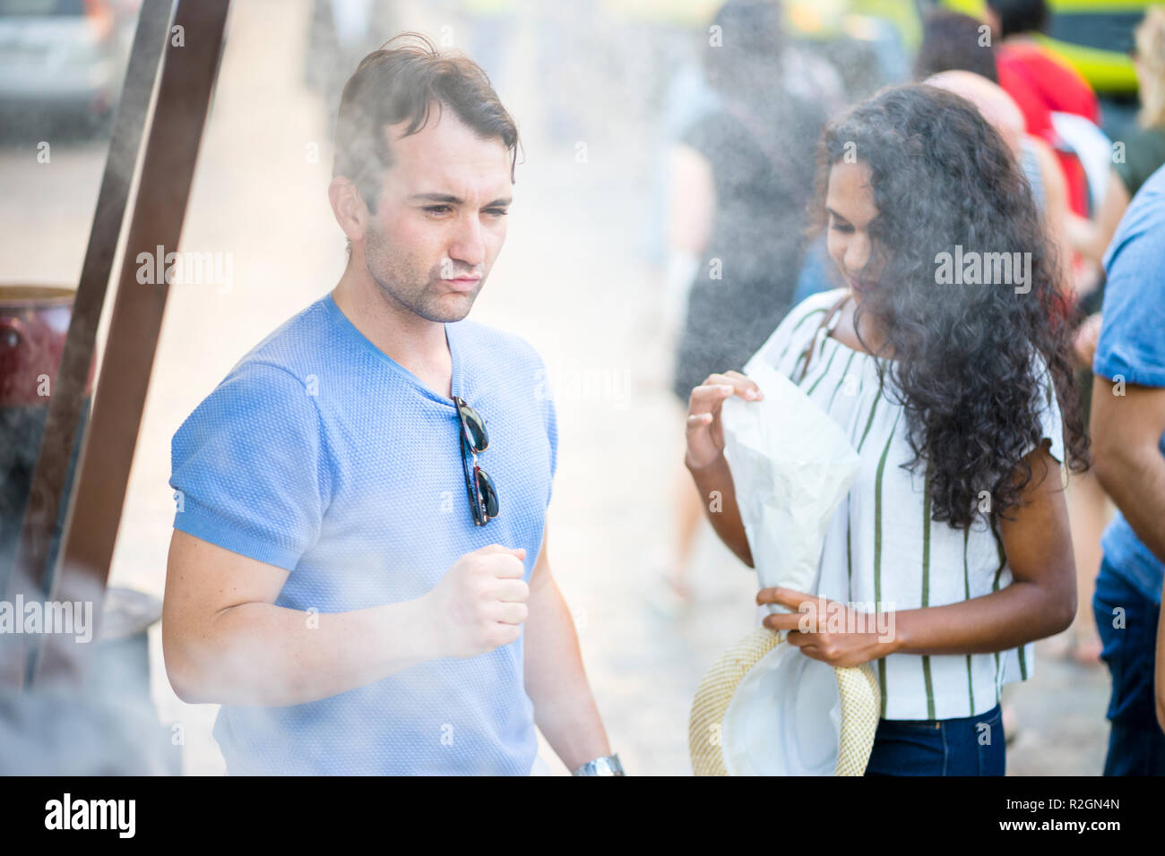 Young couple buying delicious chestnuts from street vendor, Spain Stock Photo