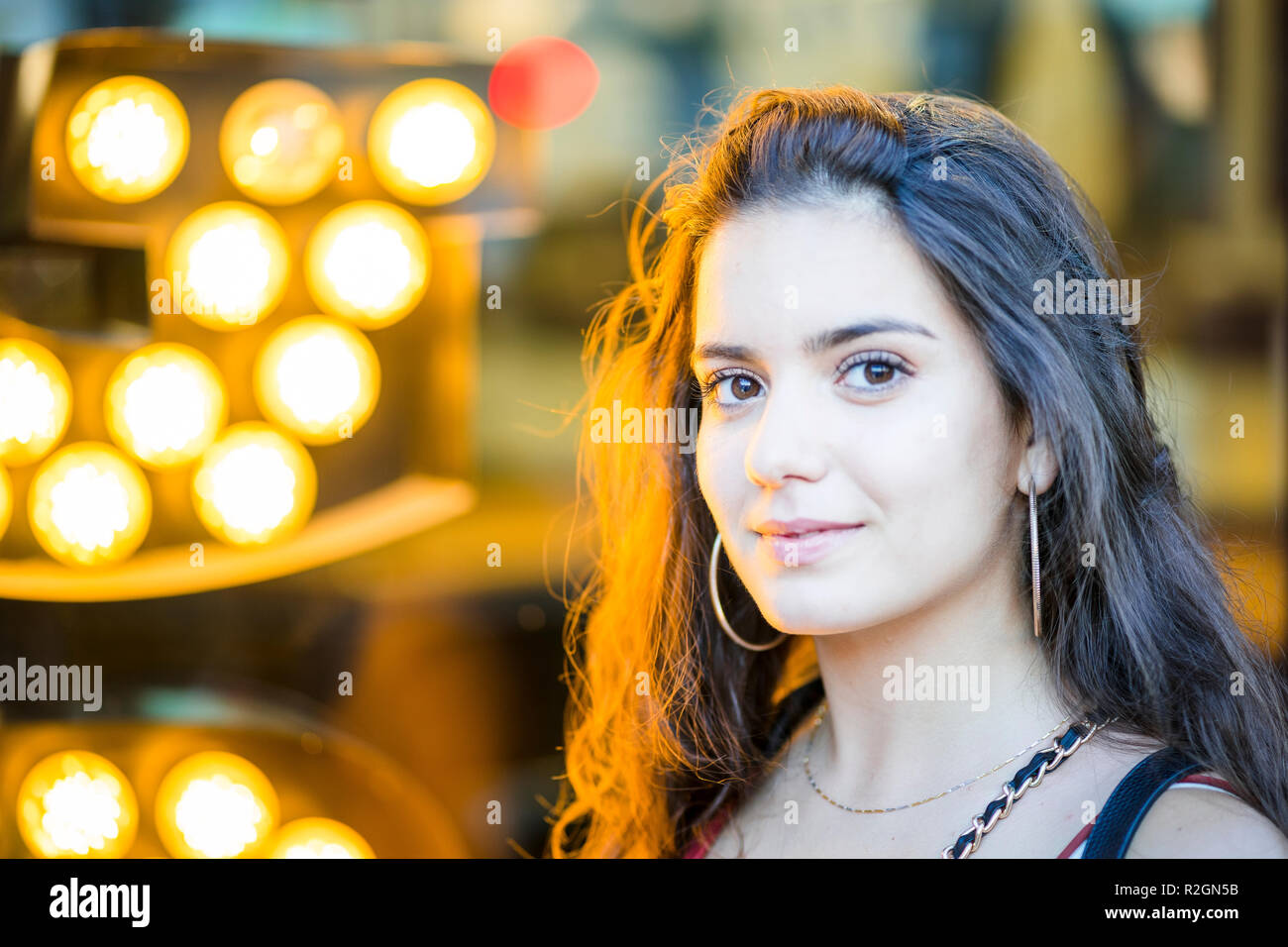 Portrait of beautiful young woman on golden lights background Stock Photo