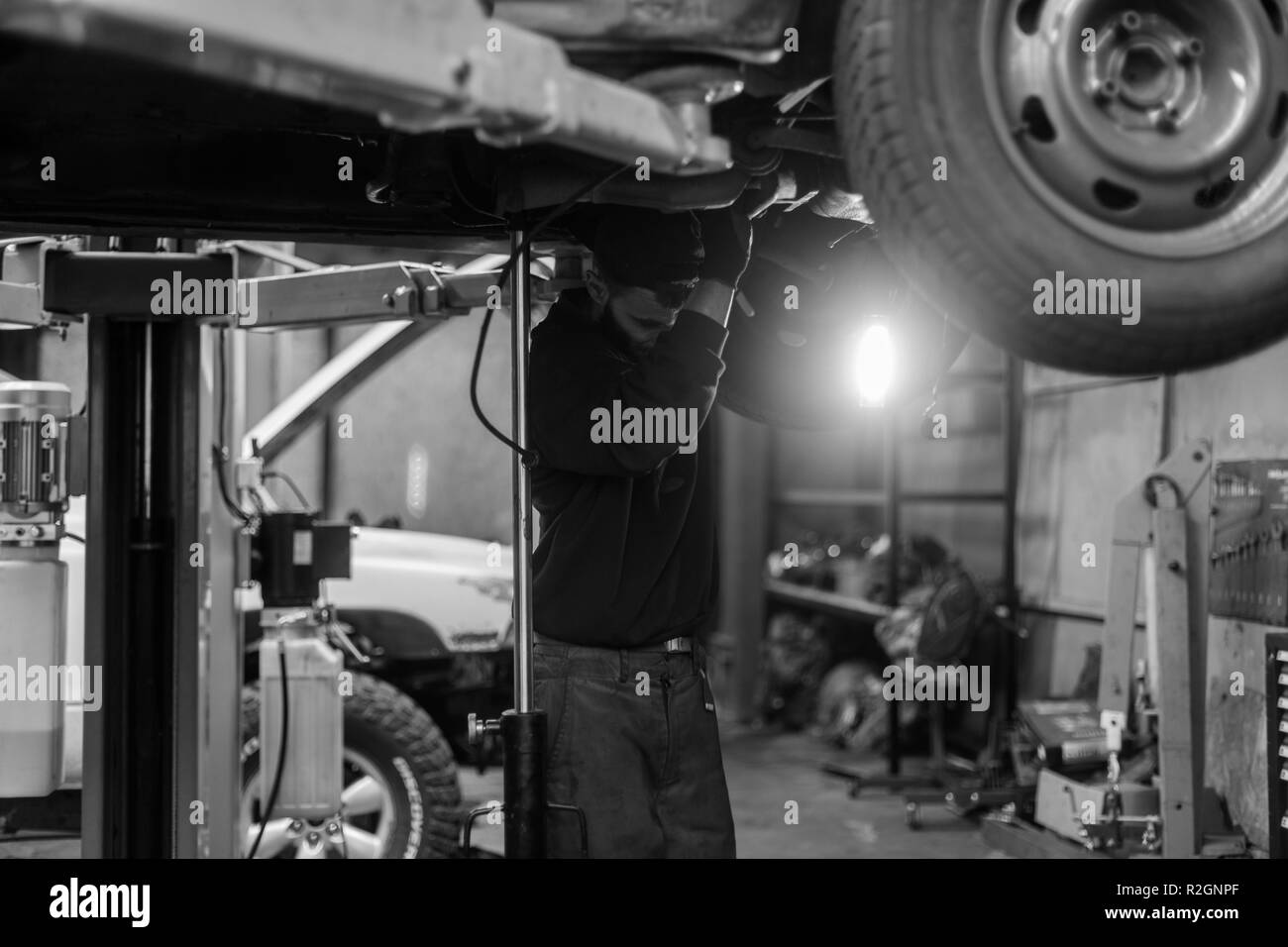 Young caucasian man repairing car with professional tools Stock Photo