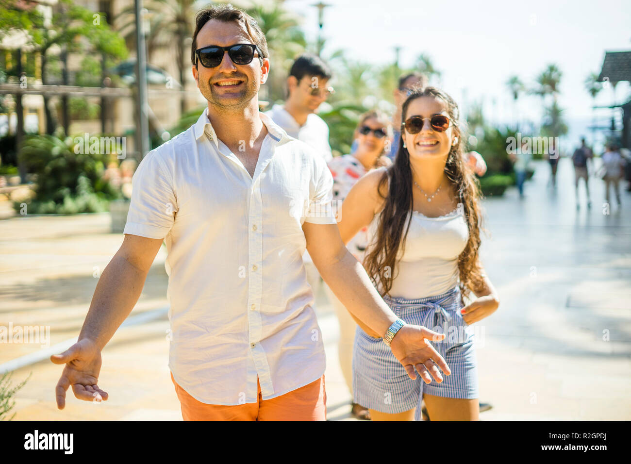Pretty girl and handsome boy hanging out with friends in the city Stock Photo