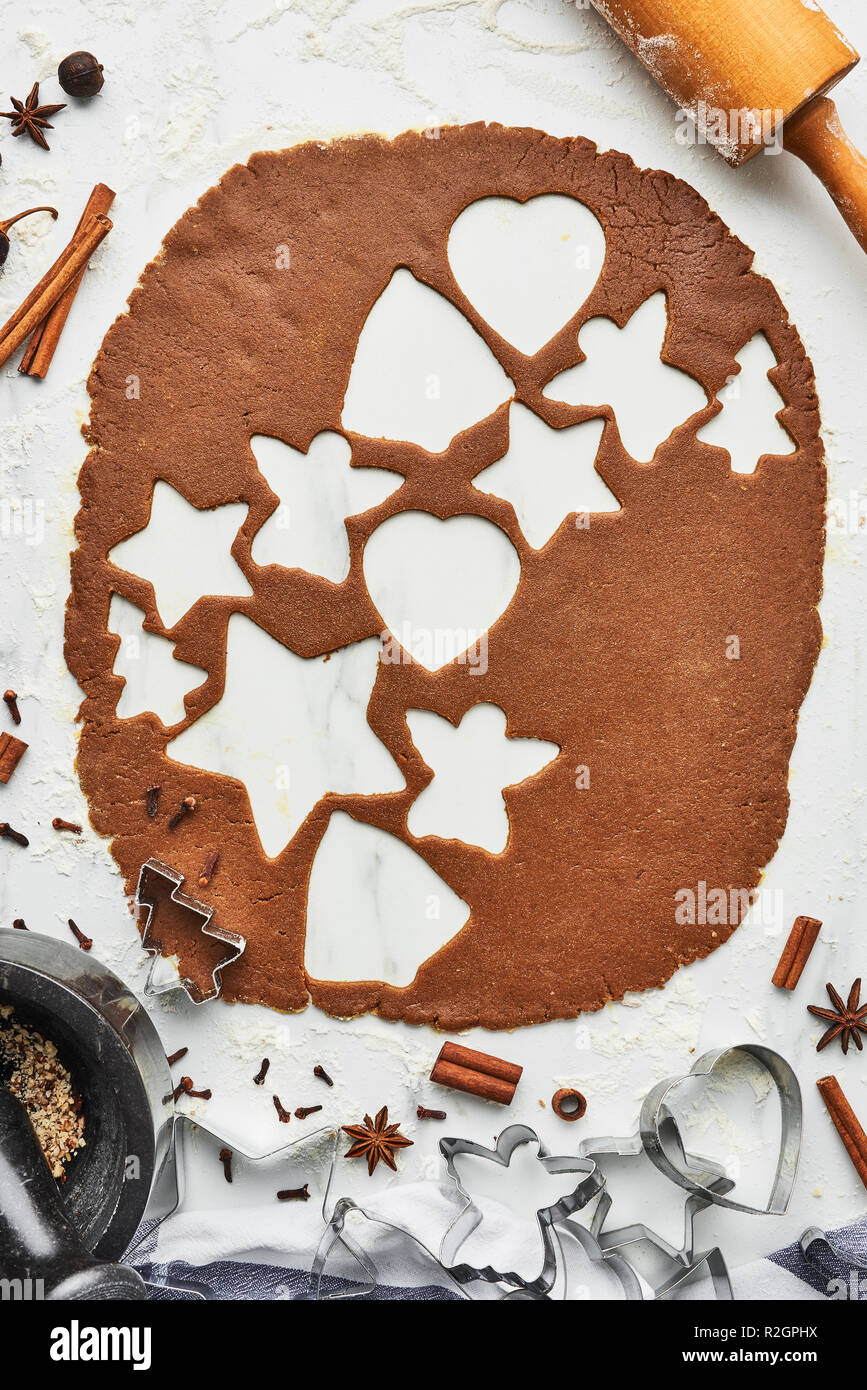 Gingerbread dough with various shape cookie cutout. Baking background for baking Christmas gingerbread cookies. Top view of cookie dough with cutters, Stock Photo
