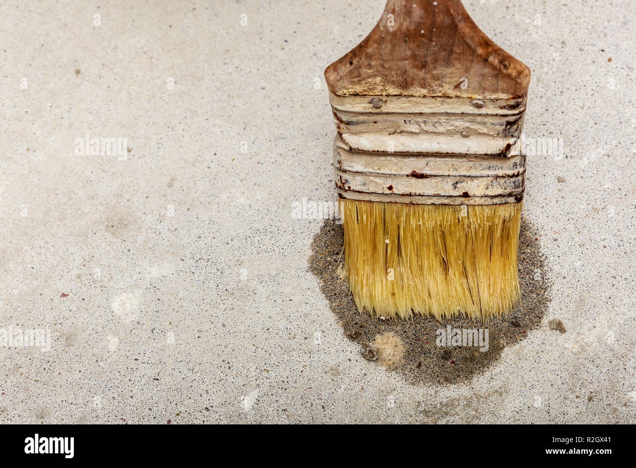 Housework renovation objects concept. Old, dirty paint brush making wet