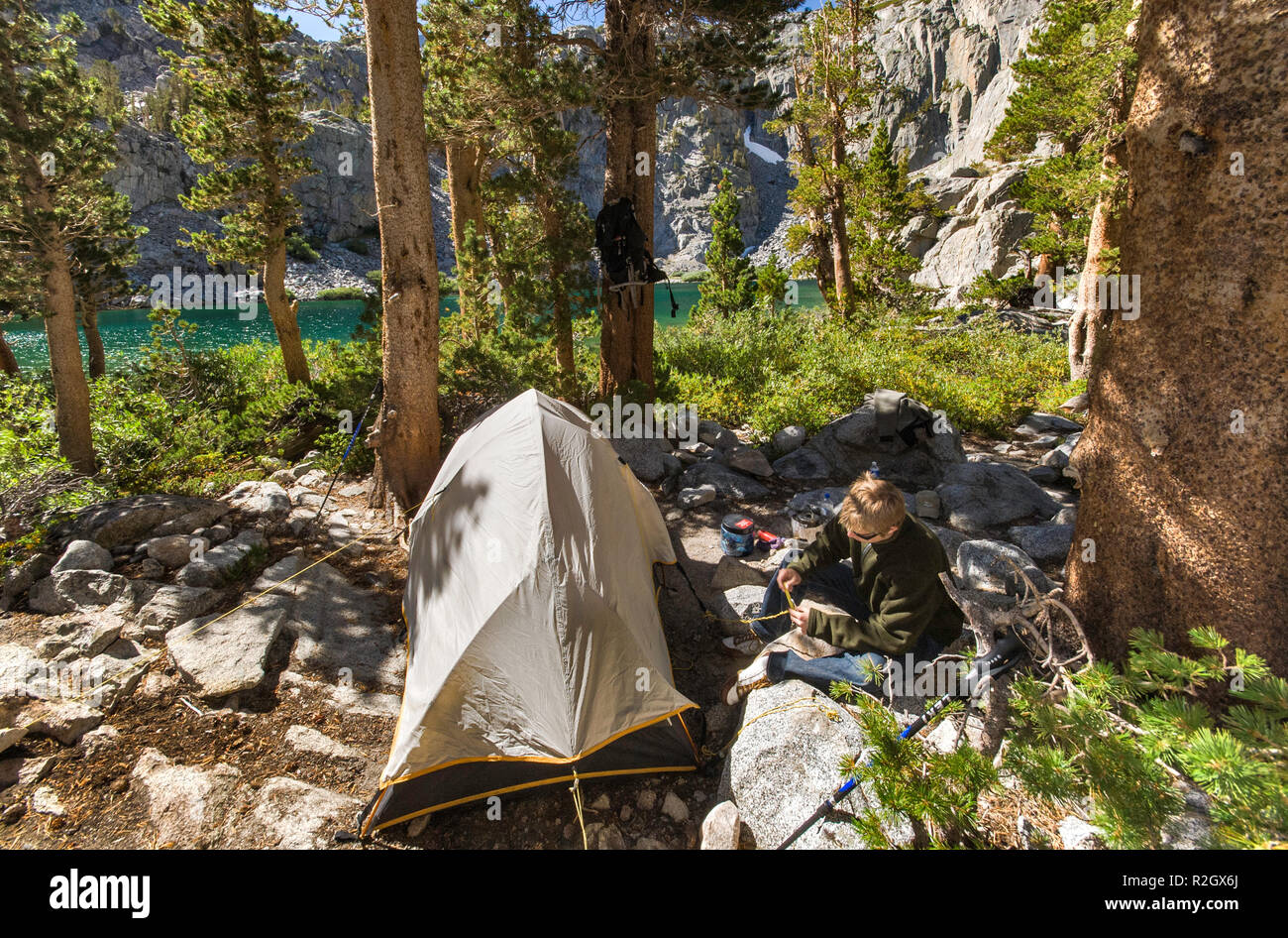 Young hiker at campsite at Brainard Lake, The Palisades region, John Muir Wilderness, Eastern Sierra Nevada, California, USA Stock Photo