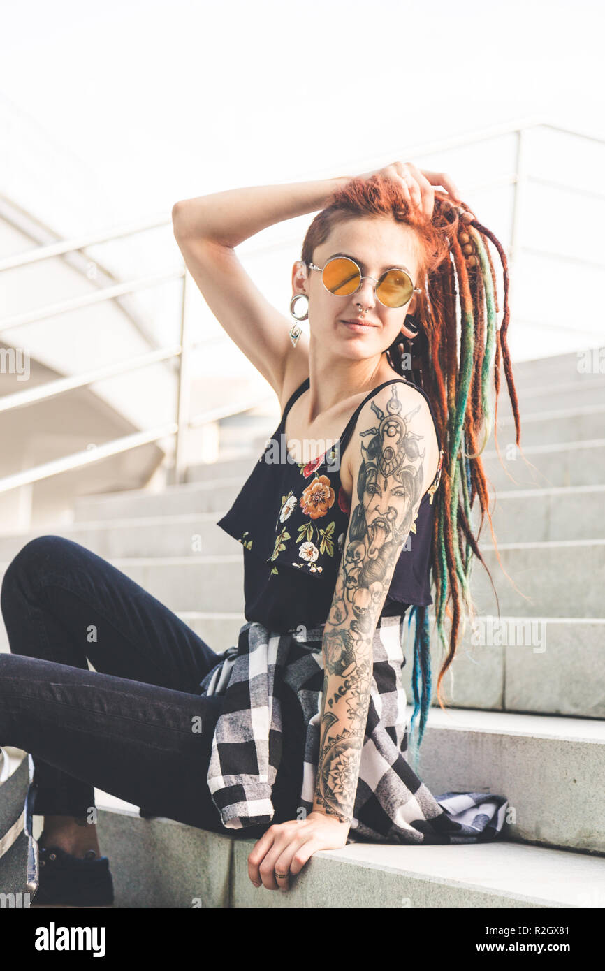 Young Girl With Tattoo And Dreadlocks Sitting On The Steps