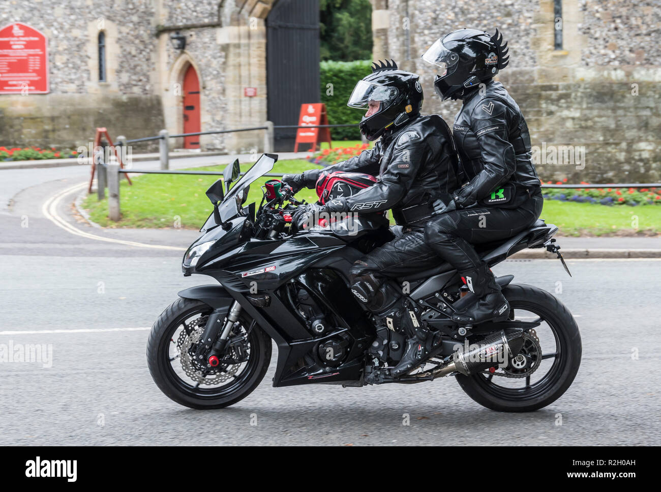 Man riding Kawasaki Z1000SX motorcycle with female pillion passenger in black leathers & protective clothing, in the UK. Stock Photo