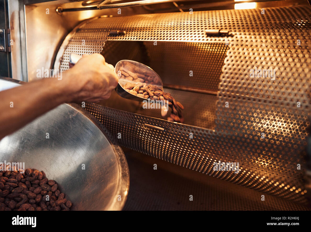 Worker in a chocolate making factory roasting cocoa beans Stock Photo