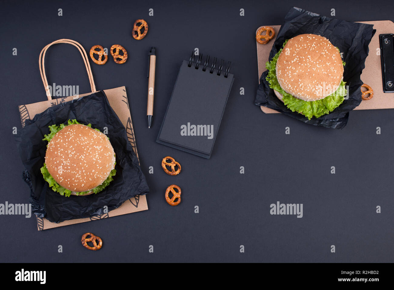 Two hamburger on a black background for lunch. Fast Food and snacks in