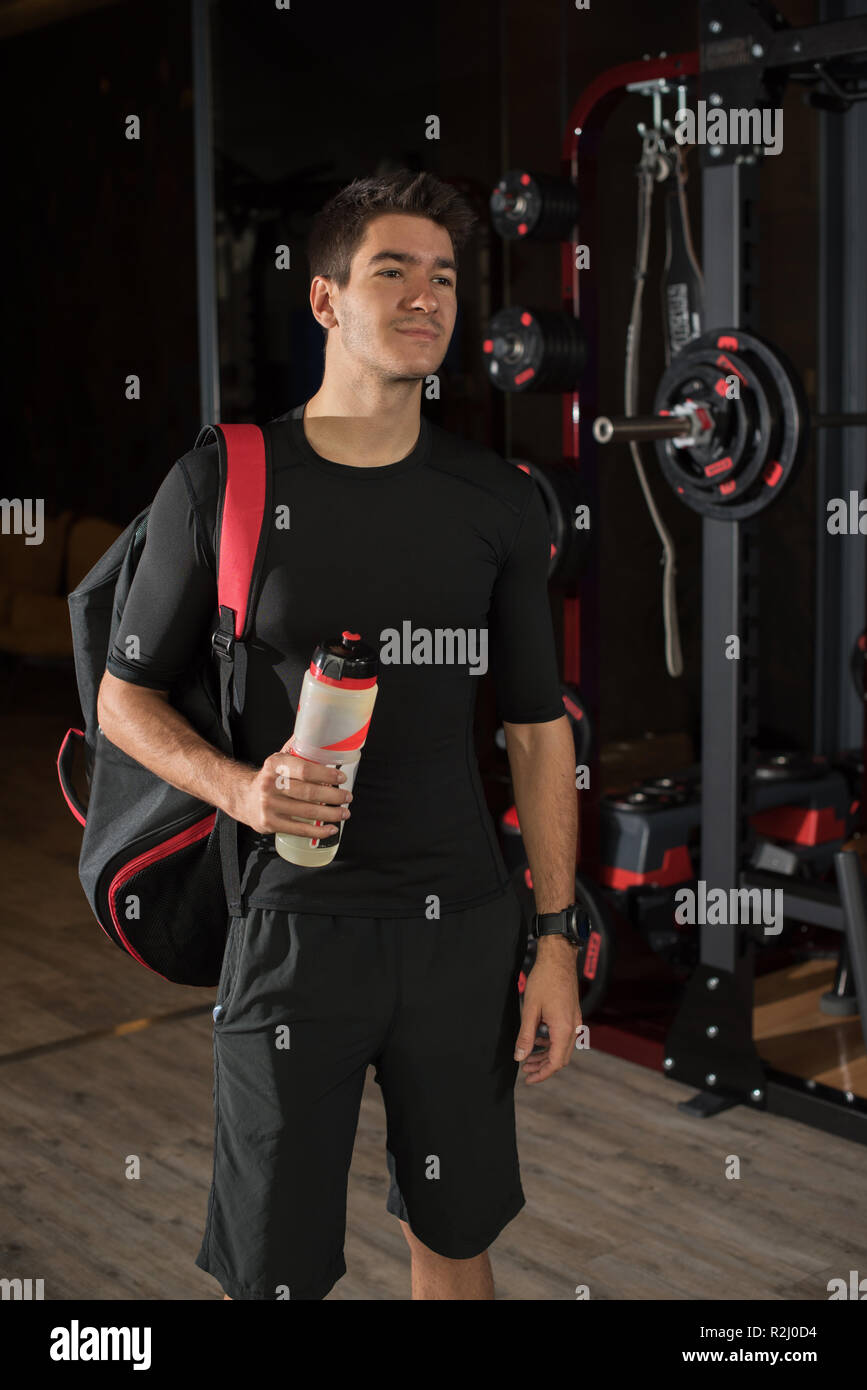 Portrait of a man standing in a gym holding a water bottle Stock Photo ...