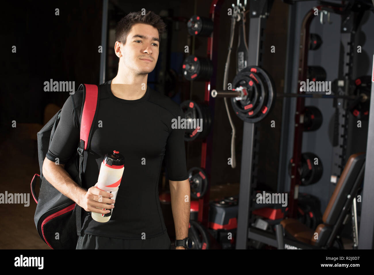 Portrait of a man standing in a gym holding a water bottle Stock Photo ...