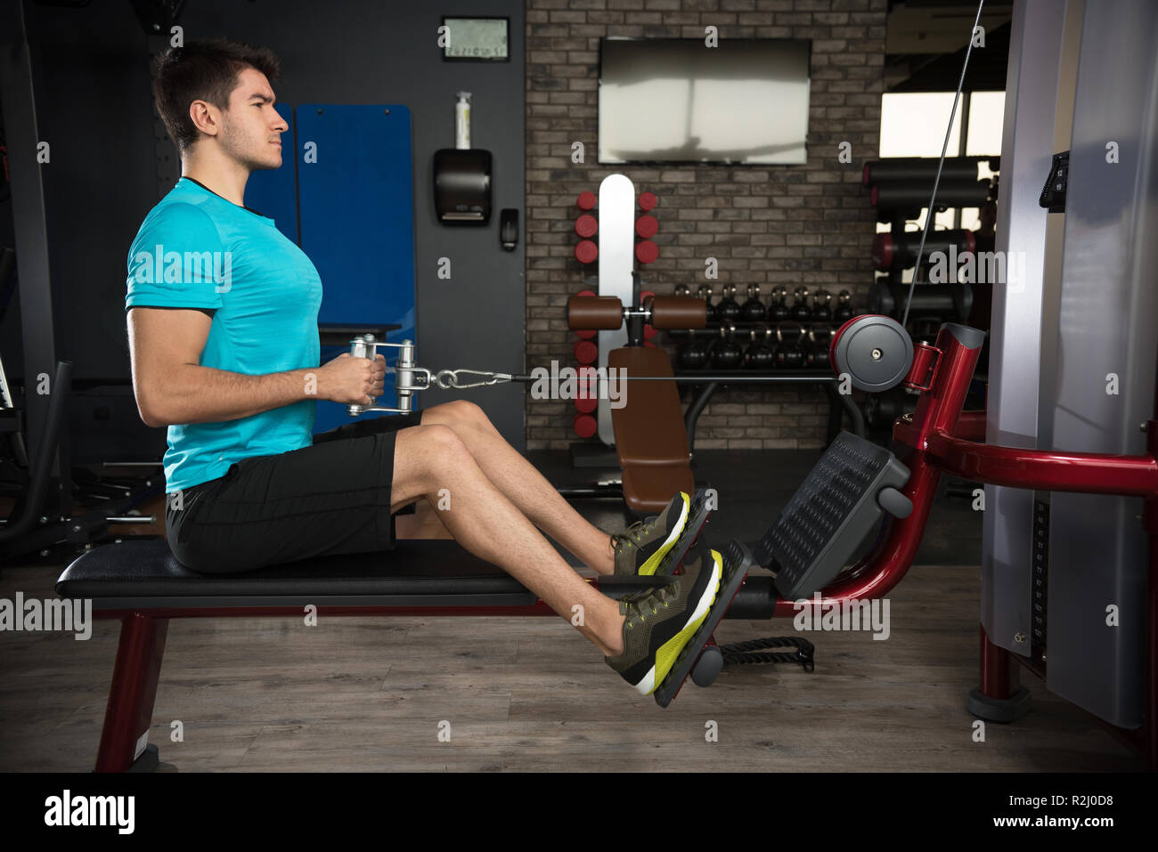 Man using a rowing machine in a gym Stock Photo - Alamy
