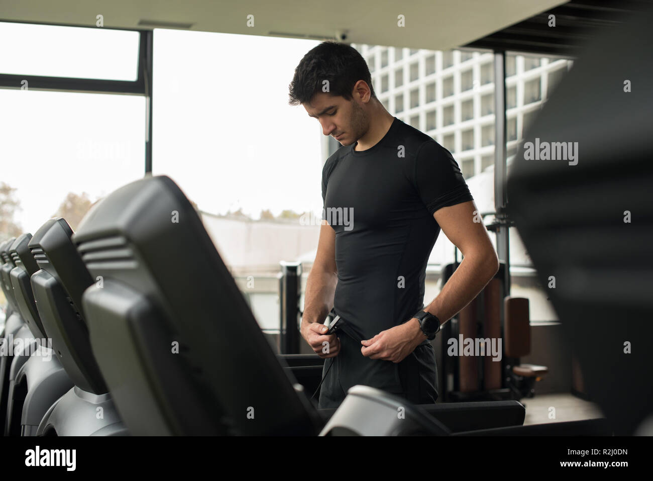 Man standing on a running machine attaching a safety clip Stock Photo -  Alamy