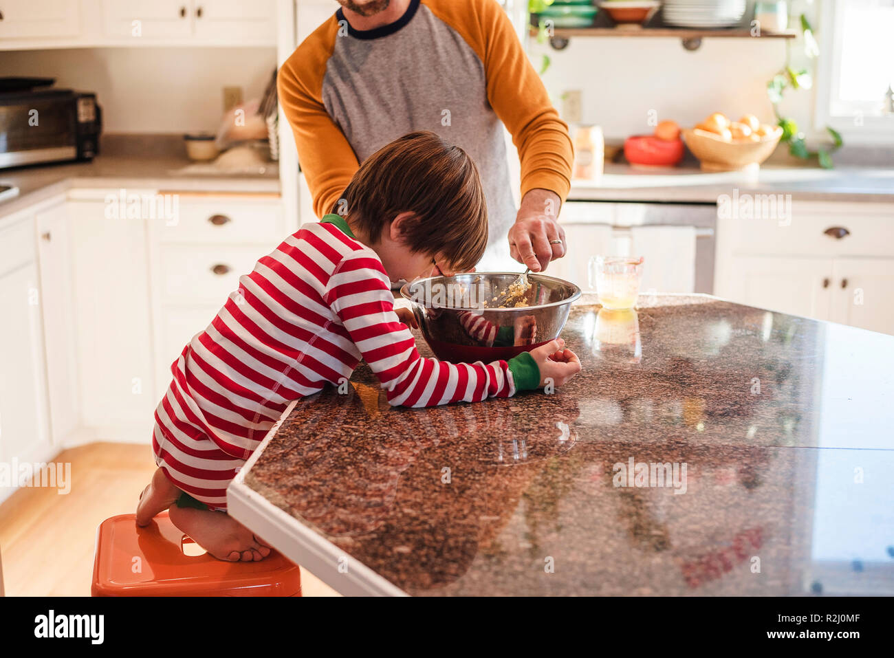 Boy helping his father bake in the kitchen Stock Photo